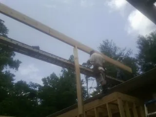 Carpenter setting a ridge beam over a new addition frame — Ice Dam Removal by Roofing Brothers in Kennerdell