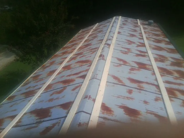 Rusted metal roof panels with new wood purlins before replacement — Storm Damage Roof Repair in Kennerdell by Roofing Brothers