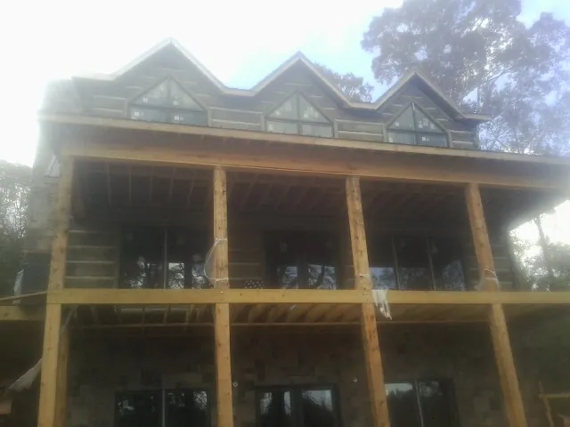Dormers and porch framing on a large log home under construction — Roof Coating work by our crew in Kennerdell