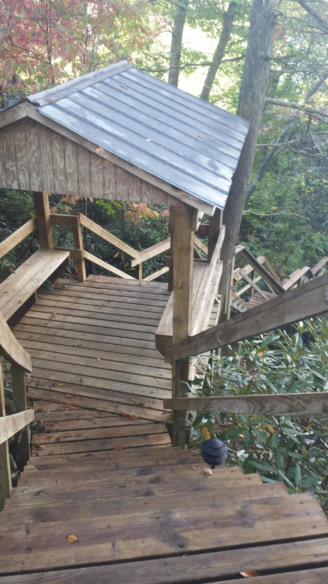 Metal roofed shelter over wooden steps on a wooded walkway — Skylight Repair & Installation work by our crew in Kennerdell