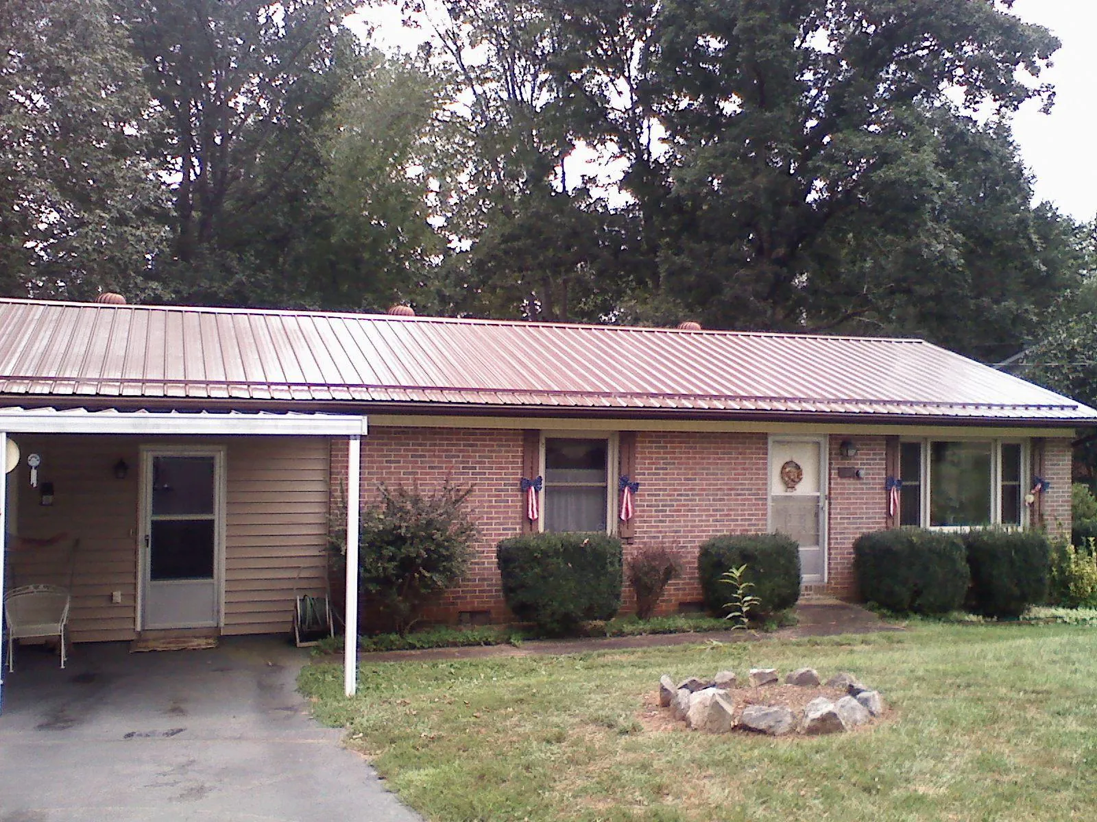 Bronze metal roof and carport on a brick ranch home — Roof Repair work by our crew in Kennerdell